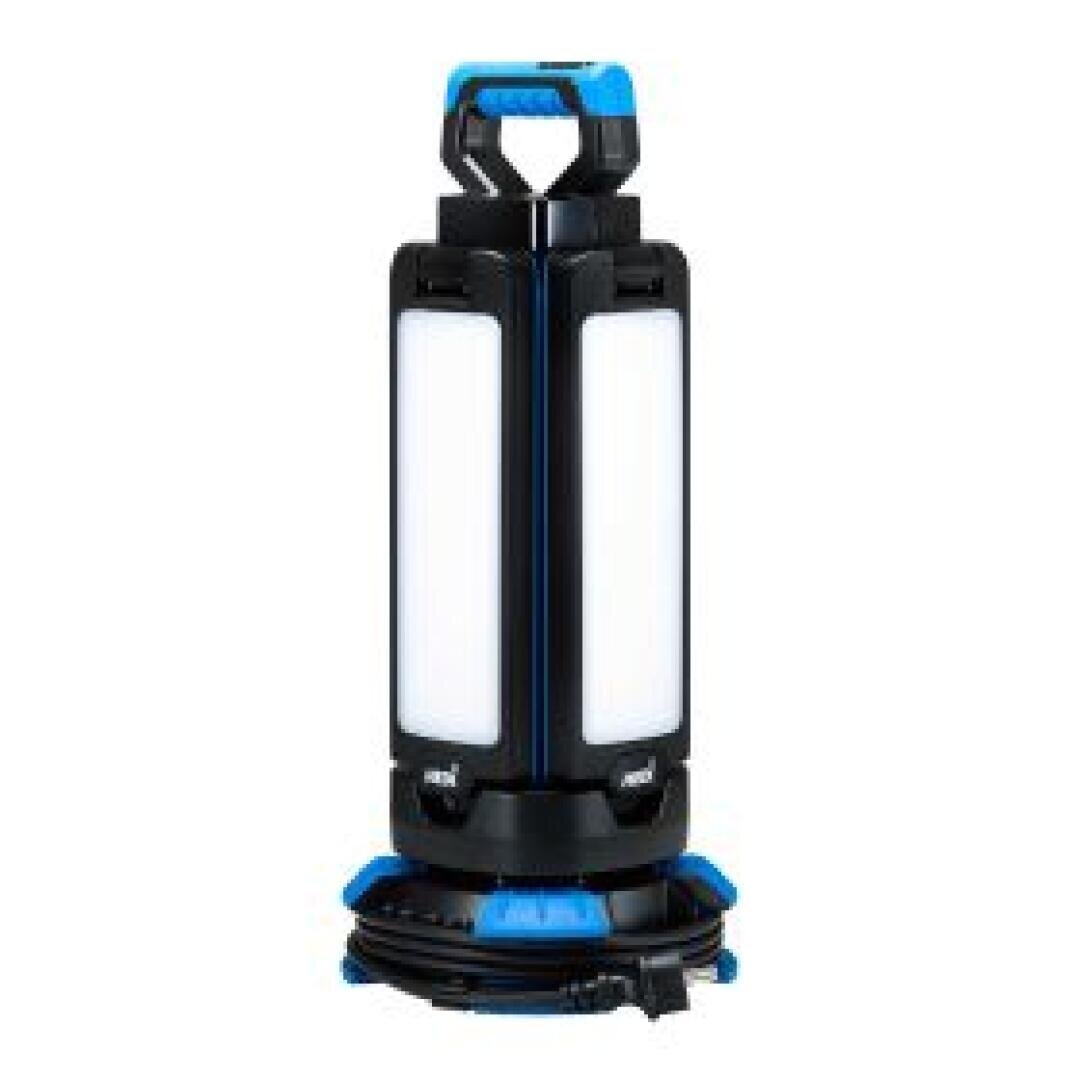 Eine tragbare LED-Arbeitsleuchte mit einem schwarz-blauen Gehäuse, rechteckigen Leuchtfeldern an den Seiten, einem Tragegriff an der Oberseite und einem um den Sockel gewickelten Netzkabel.