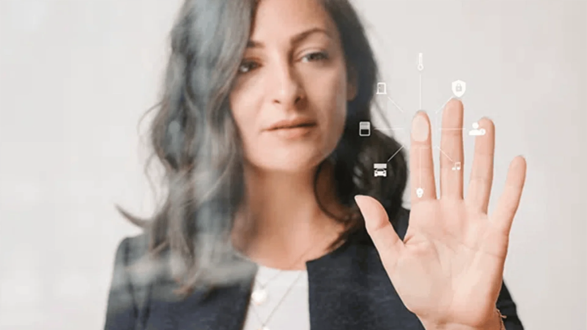 Eine Frau mit gewelltem Haar berührt einen transparenten Bildschirm mit digitalen Symbolen, die auf die Interaktion mit einer futuristischen Technologie oder einer virtuellen Schnittstelle hindeuten.