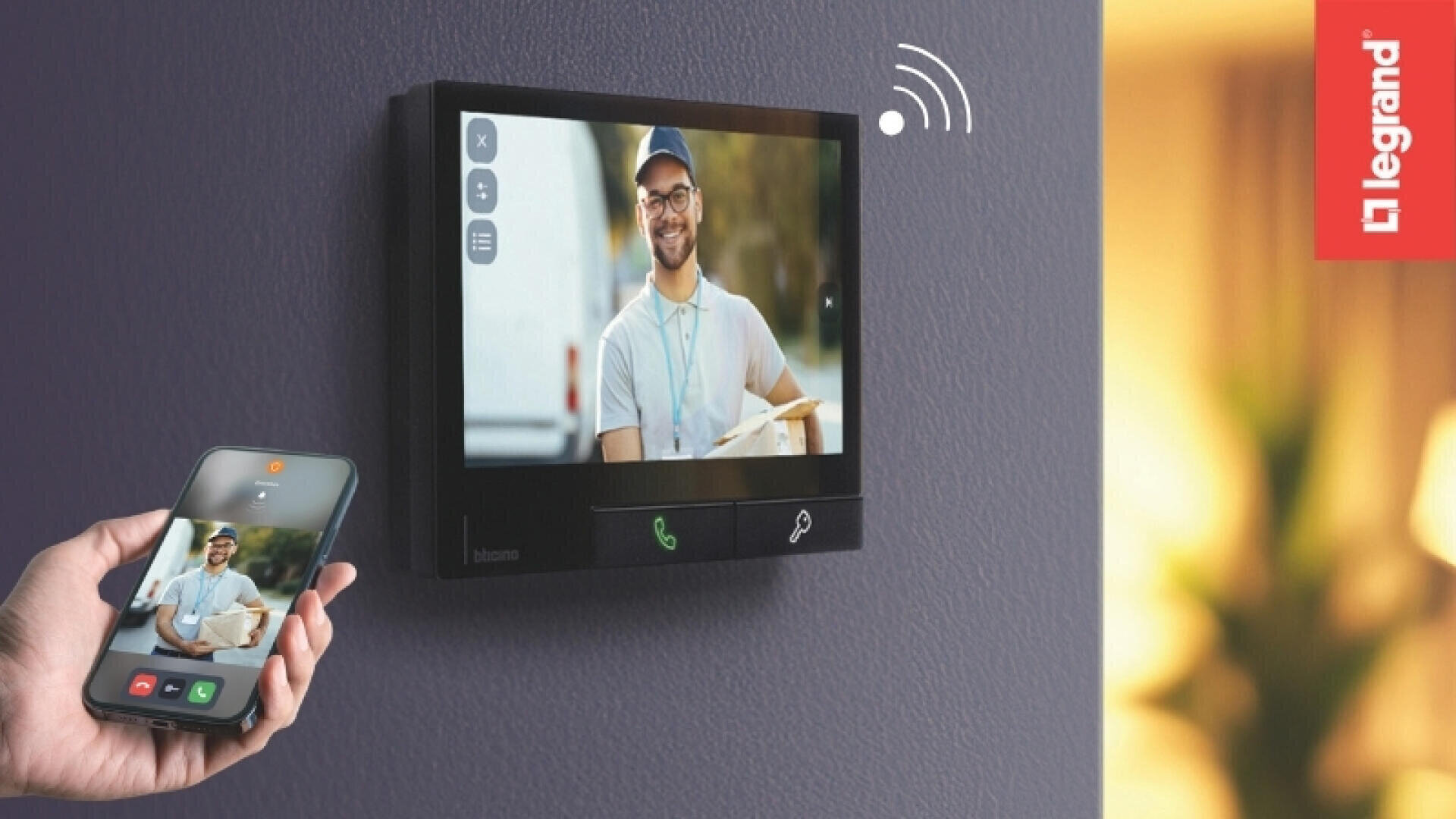 Un smartphone et un interphone vidéo fixé au mur montrent le même appel vidéo avec un livreur souriant qui tient un colis à la main. Sur le côté droit, on peut voir le logo Legrand.