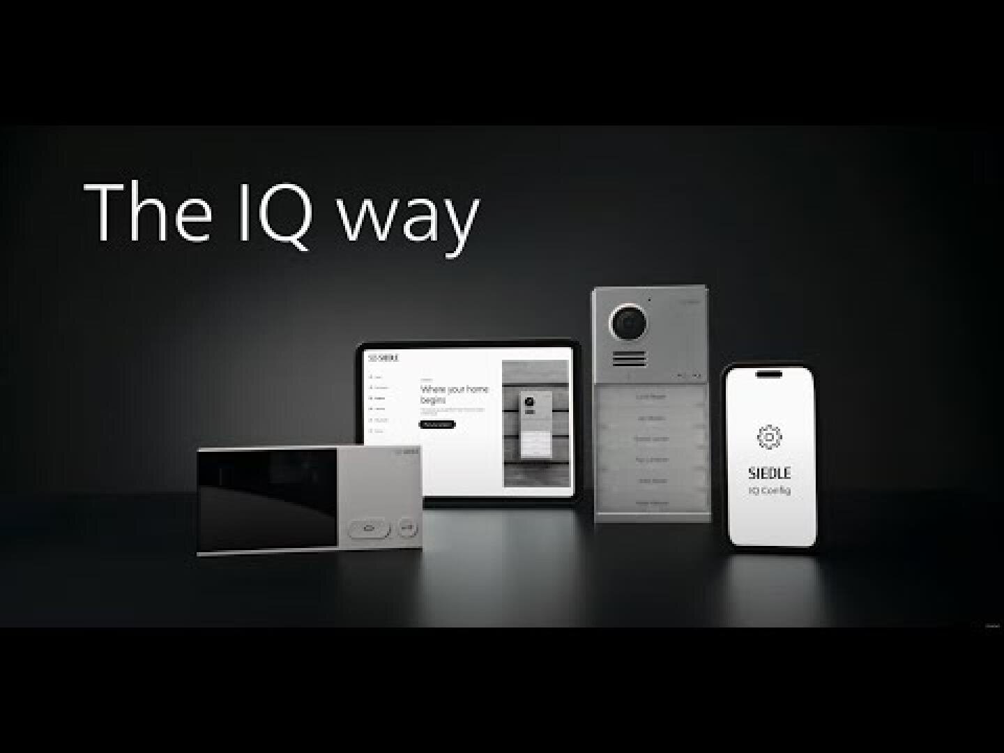 Quatre appareils domotiques au design épuré sont présentés sur un fond noir, sous le texte « The IQ way ». Il s'agit d'une tablette, d'un écran tactile, d'un interphone et d'un smartphone.