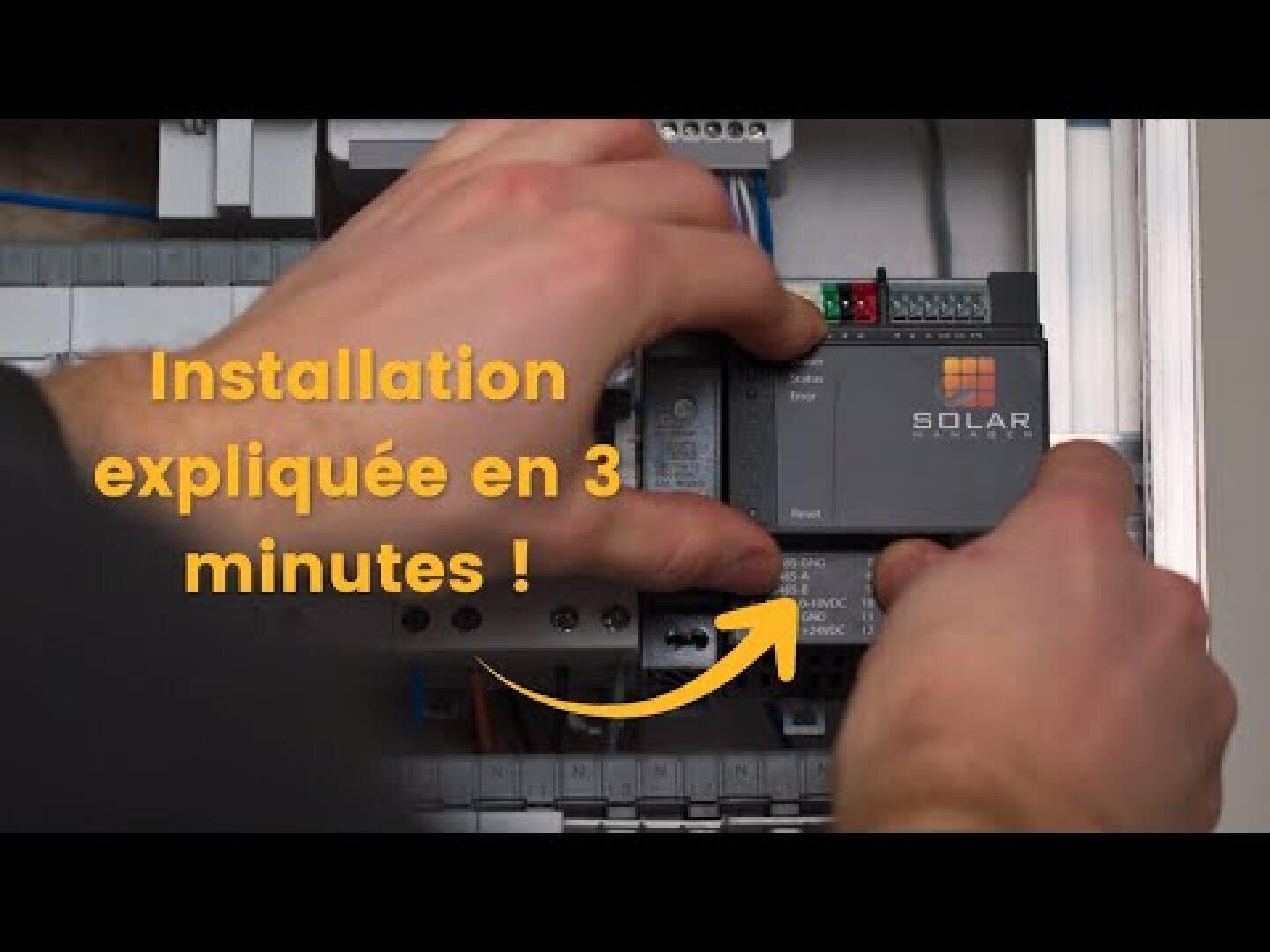 Les mains d'une personne installent un appareil électronique de marque Solar dans un panneau de commande. Le texte jaune en français indique "Installation expliquée en 3 minutes !" avec une flèche pointant vers l'appareil.