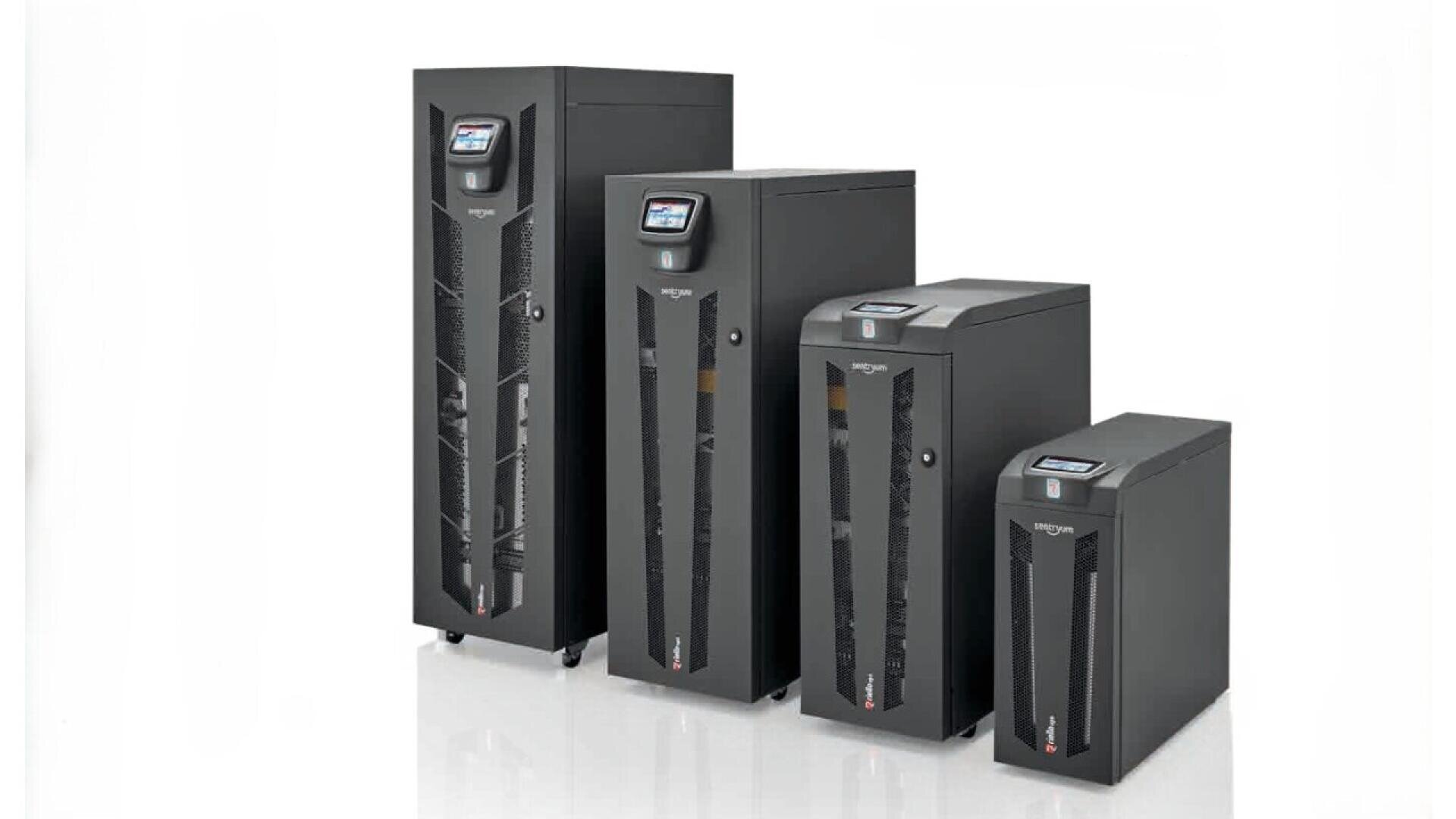 Quatre unités d'alimentation sans interruption (ASI) de différentes tailles sont alignées côte à côte sur un fond blanc, chacune avec un affichage numérique en haut.
