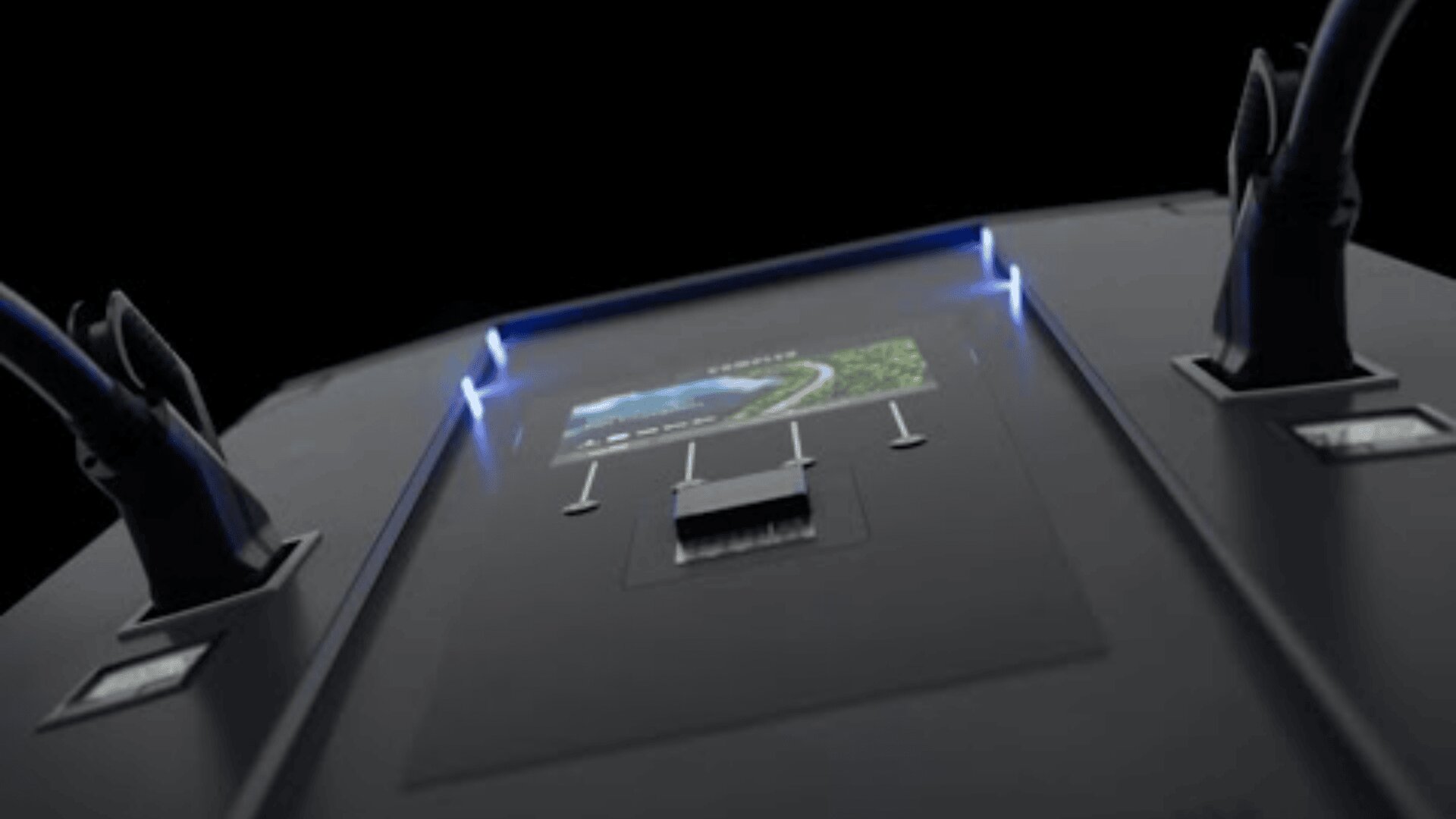 Nahaufnahme einer schwarzen elektronischen Ladestation mit zwei angeschlossenen Kabeln, einer digitalen Anzeige, die eine Straße zeigt, und blauen Kontrollleuchten auf beiden Seiten vor einem dunklen Hintergrund.