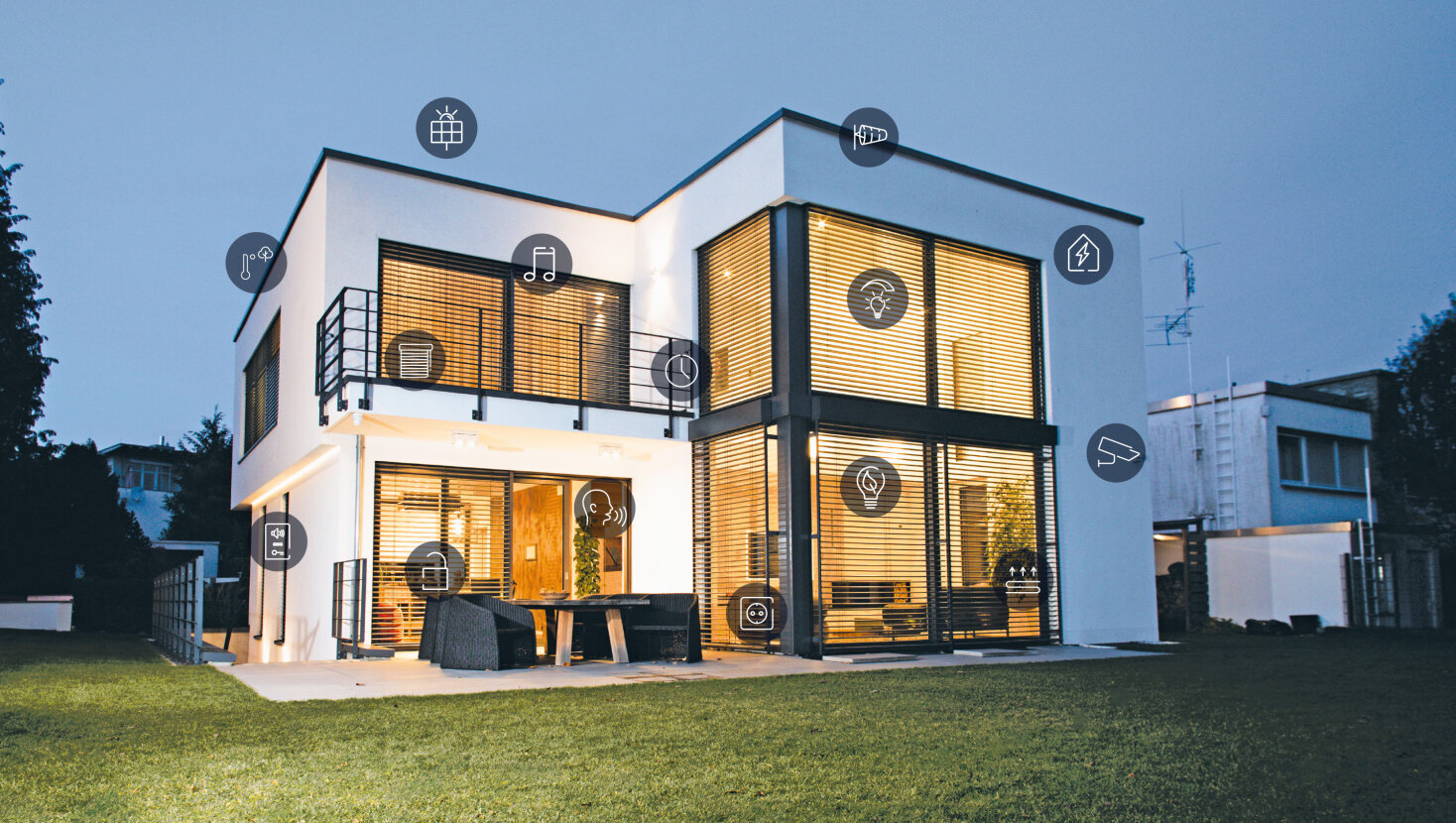 Modernes zweistöckiges Haus in der Abenddämmerung mit großen Fenstern, leuchtenden Innenlichtern und verschiedenen überlagerten Smart-Home-Symbolen, die vernetzte Geräte und Technologien innerhalb und außerhalb des Hauses darstellen.